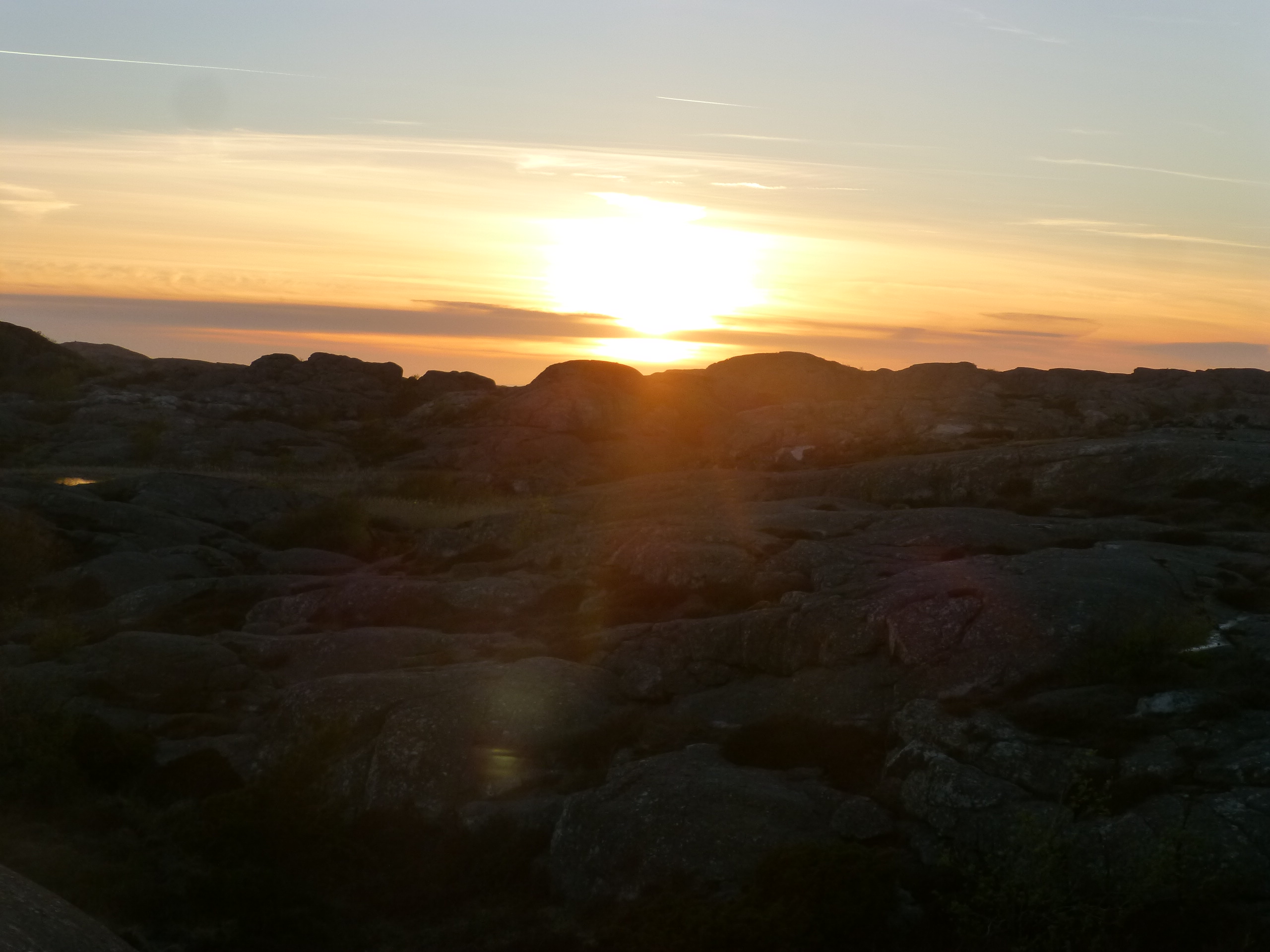 Die Sonne versinkt hinter den Felsen bei Skärhamn